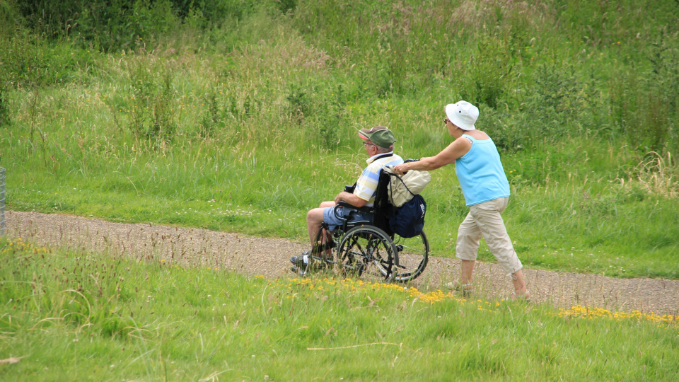 kvinde skubber mand i kørestol
