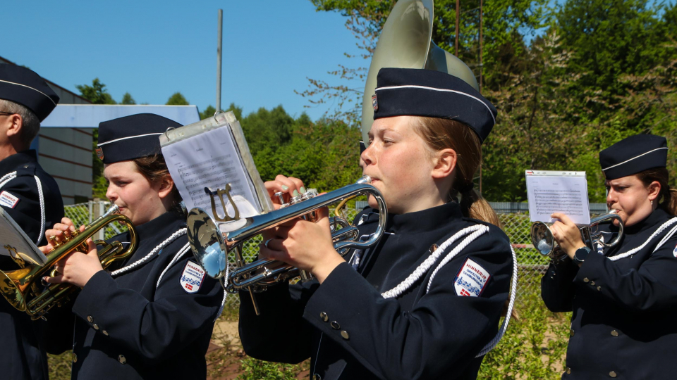 Pige spiller trompet i garden