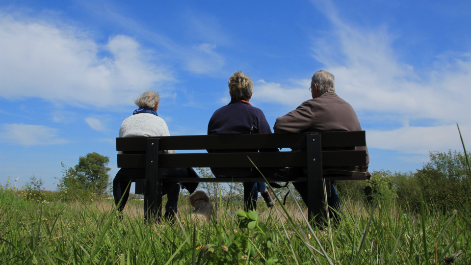 Tre personer på en bænk udenfor