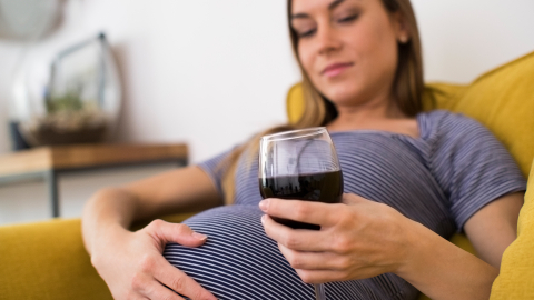 Gravid med rødvin i glas