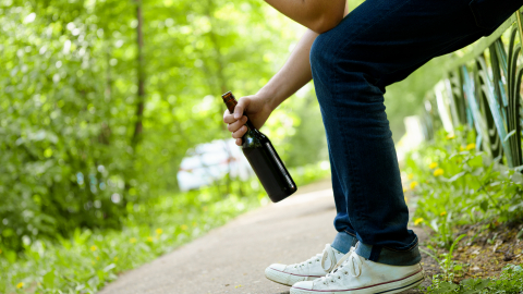 Person med vinflaske udenfor