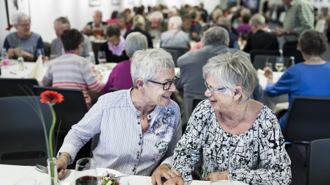 To damer griner og smiler til hinanden