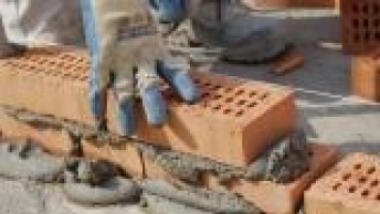 Håndværker i gang med at mure en væg op