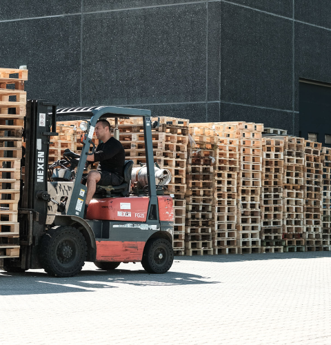 Paller fragtes af mand i gaffeltruck