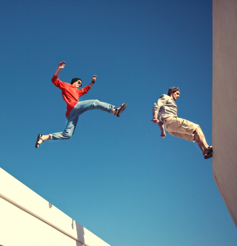 to personer der laver parkour på hustage