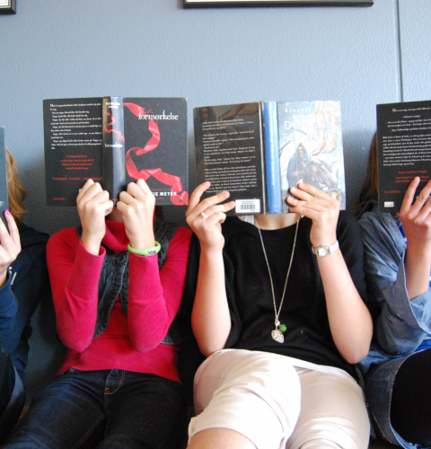 Hænder holder bøger, der skjuler hoved