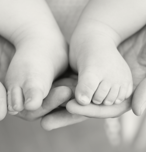 Hænder holder babyfødder