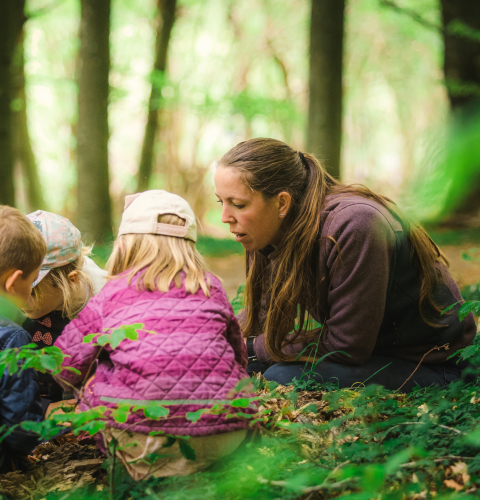Voksen med børn i skoven